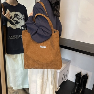 Close-up of a brown corduroy tote bag showing thick texture and woven label detail