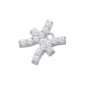 Macro shot of silver cross pendant with white pearls for DIY jewelry making