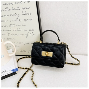 Close-up of black quilted mini bag with gold chain strap and turn-lock closure