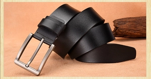 Close-up of premium black leather belt with vintage square metal pin buckle on texture
