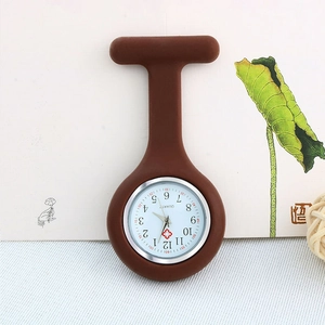 Detail view of a brown silicone nurse watch featuring a white dial and medical cross icon