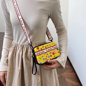 Détail de la sacoche jaune avec des points colorés et des motifs d'animaux en cuir PU