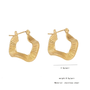 Macro detail of gold wavy texture earrings in polished stainless steel for women