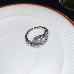 Macro shot of silver snake-shaped ring encrusted with sparkling white zircons