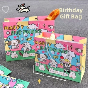 Close-up of birthday gift bag with cute cartoon illustrations and woven handle