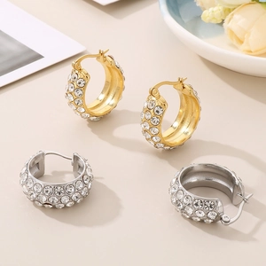 Close-up of gold and silver hoop earrings with shimmering crystal pavé inlays