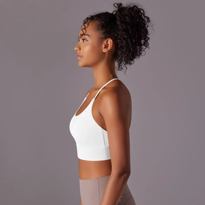 Side view of white halter yoga bra with thin straps and grey-purple high-waisted leggings
