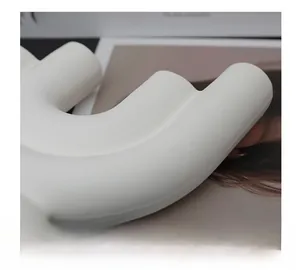 Detail einer wellenförmigen Keramikvase mit matter Textur und minimalistischem Kunststil