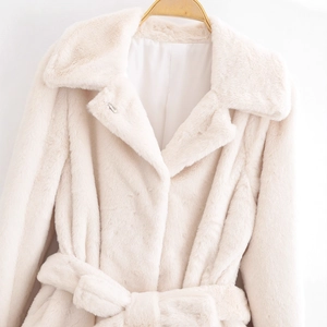 Elegant beige faux fur coat with oversized lapels and matching waist belt on white background