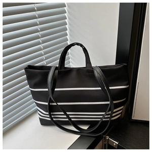 Detailed view of striped canvas tote bag with dual handles and long shoulder straps