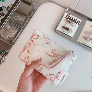 Close-up of floral cotton pouch with pink cord zipper and simple wish label