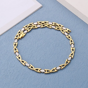 Detail of interlocking gold and silver titanium steel bracelet on a textured background