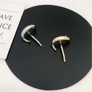 Close-up of minimalist gold and silver polished metal hair sticks set on a black tray
