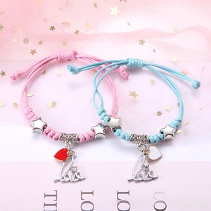Detail von gewebten Paararmbändern mit herzförmigen Anhängern und Sternperlen in Rosa