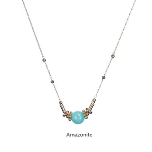 Macro detail of natural light blue Amazonite bead pendant on gold stainless steel chain