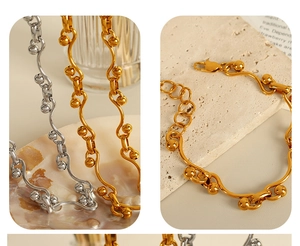 Detailed macro view of wavy gold and silver titanium steel link bracelets with bead accents