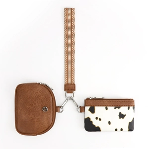 Dettaglio del set con pochette in finta pelle marrone, porta carte muccato e cinturino intrecciato