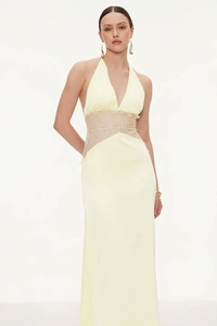 Détail de robe longue en satin jaune clair avec col licou et empiècements en dentelle