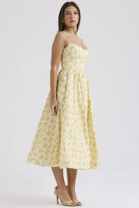 Detail of a floral midi camisole dress with delicate straps and a slim waistline on a model
