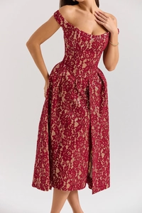 Gros plan sur une robe en dentelle rouge à épaules dénudées montrant les broderies détaillées