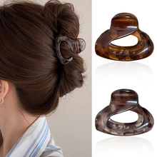 Detail view of matte floral hair claw clips with tortoiseshell pattern on a model