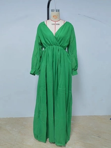 Detail view of the V-neckline and pleated waist on the green maxi dress on a mannequin