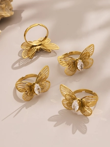 Detailed view of four gold-toned butterfly rings with shimmering marquise cubic zirconia stones
