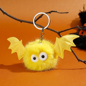 Détail d'un porte-clés chauve-souris en fourrure jaune avec de grands yeux sur branche