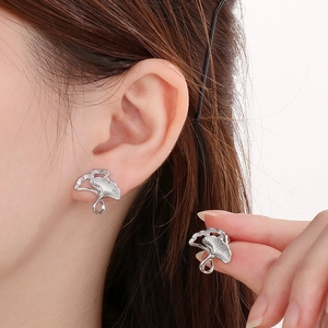 Detailed view of silver ginkgo leaf stud earrings worn to show elegant shape and finish