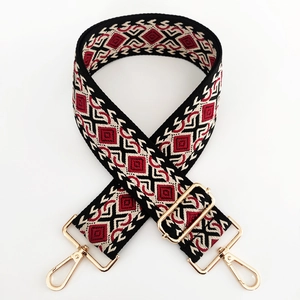 Detail of diamond jacquard ethnic shoulder strap with golden metal hardware and swivel hooks