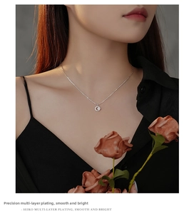 Detail of s999 sterling silver moon necklace with sparkling cubic zirconia on model neck