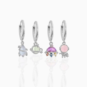 Detail of space-themed earrings featuring astronauts and planets with colorful cubic zirconia