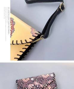 Macro detail of ethnic floral print, thick black stitching and gold-tone metal hardware