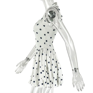 Side view of white polka dot sleeveless mini dress with pleated waist on a model