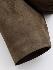 Close-up of brown faux suede texture and hem stitching on bomber jacket fabric