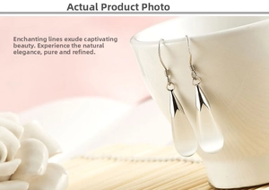 Macro shot of S925 silver hooks with milky white teardrop opal earrings on a tea cup