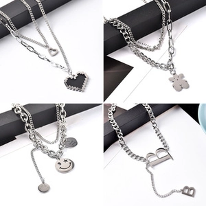 Dettaglio del set di collane in argento con ciondoli a cuore, orso e smiley