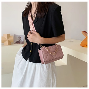 Detail of pink quilted crossbody bag with jacquard letter strap and chain handle