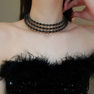 Close-up of elegant three-row black beaded choker necklace on model neck and collarbone