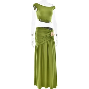 Detail of green two-piece skirt set showing ruching and gold buckle on the waistline