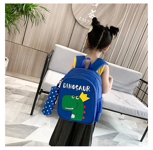 Blue kids dinosaur backpack set with matching pencil case shown from back on child