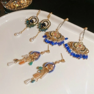 Détail macro de boucles d'oreilles de luxe vintage avec perles et pompons sur plateau