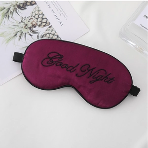 Detail of soft purple silk sleep mask with black Good Night embroidery and elastic strap