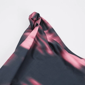 Détail du tissu tie-dye rose et gris présentant un nœud élégant au niveau de l'épaule