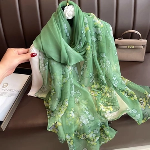 Detail view of light green floral chiffon scarf showing delicate drape and texture