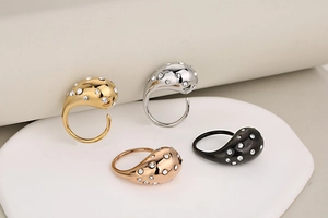 Detail view of water-drop rings in gold, silver, rose gold, and black with rhinestones