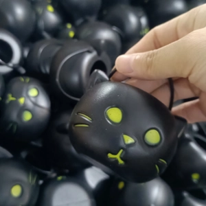 Close-up of a black plastic cat-shaped candy jar with yellow facial details for Halloween