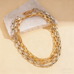 Detail of mixed-metal link chain necklace on stone, minimalist gold and silver jewelry