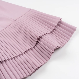 Détail de volants plissés multicouches sur une mini-robe rose violette élégante