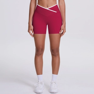 Close-up of red high-waisted yoga shorts with crossover waistband and white contrast piping